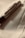 A luxurious pen with metallic accents rests on a smooth, light-colored fabric. The pen's clip has an engraved logo, contributing to its elegant appearance.