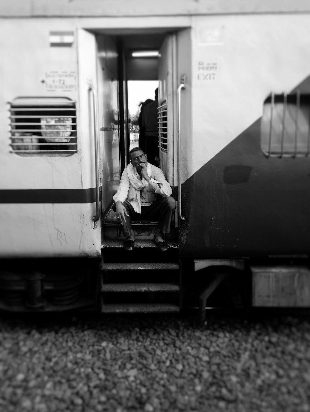 a person sitting on the door of a train