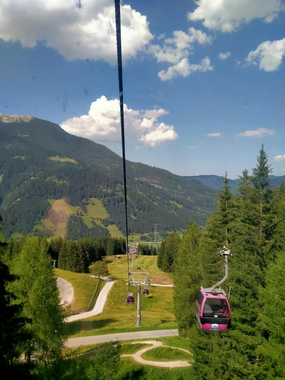 a car on a road with trees and mountains in the background