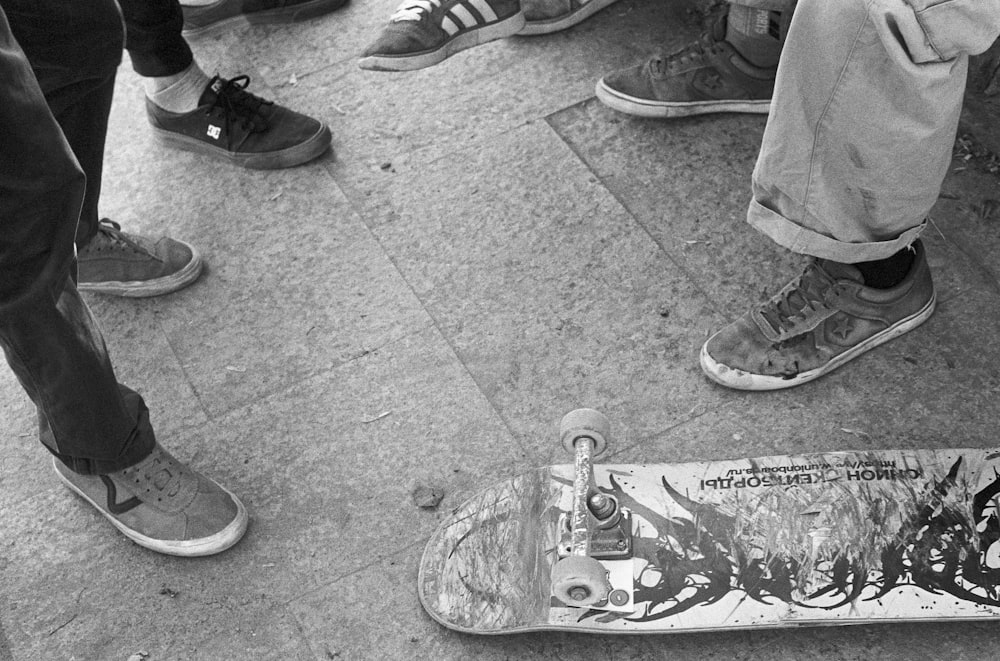 a group of people stand around skateboards