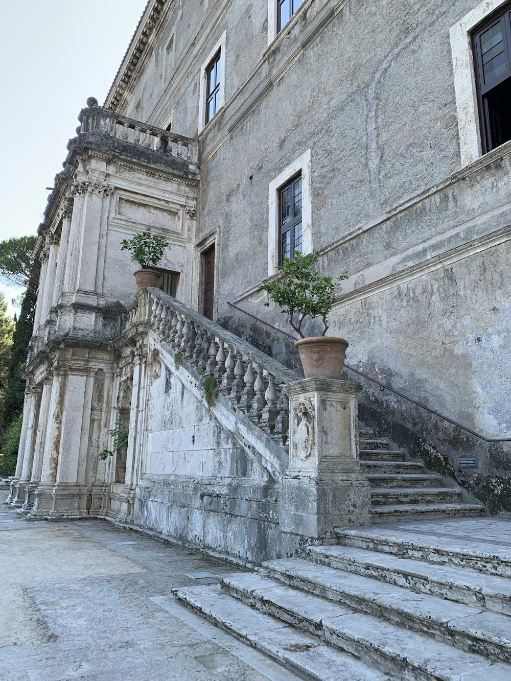 a stone building with plants on the stairs
