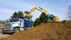 a truck loading a large piece of dirt into a truck