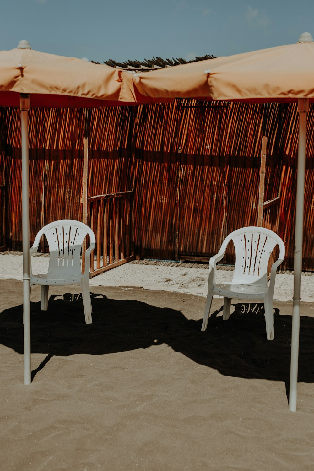a couple white chairs under a red tent
