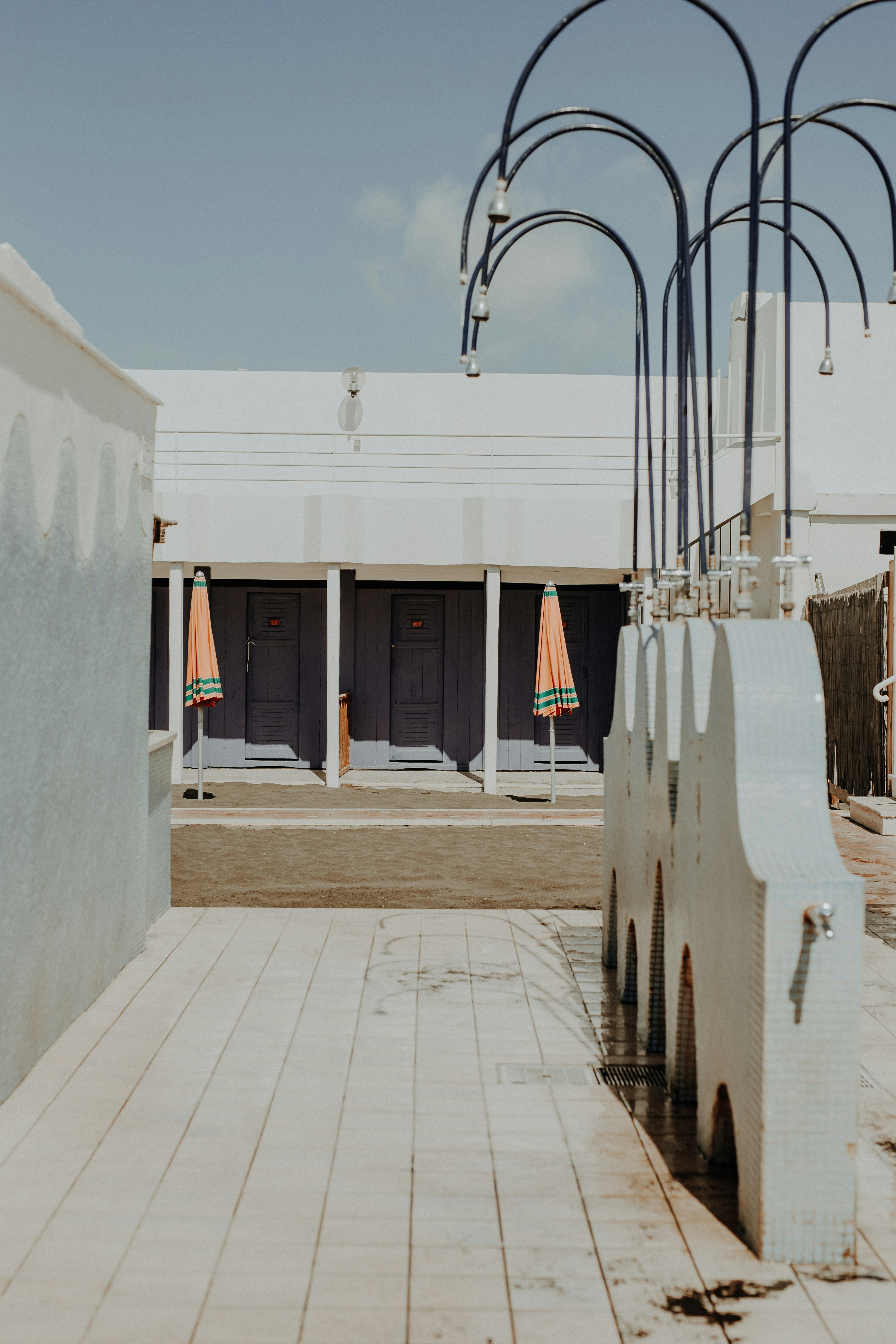 a walkway with a lamp post and a building with a gate