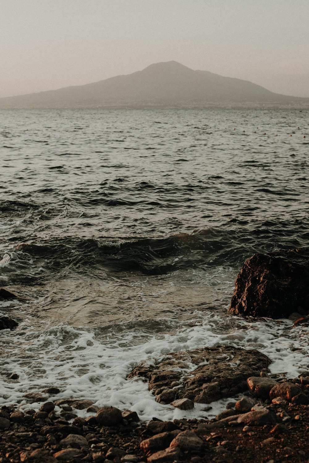 a rocky beach with a mountain in the background