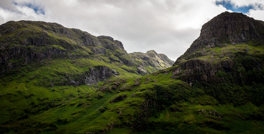 a grassy valley with mountains in the background