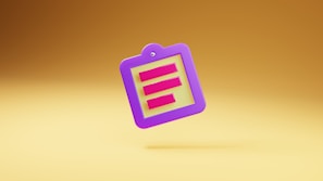 A colorful, three-dimensional clipboard icon with a purple border and yellow center, featuring three horizontal red lines resembling text. The clipboard is floating against a gradient golden background.