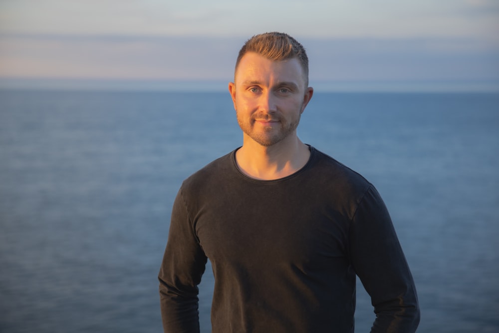 a man standing in front of a body of water