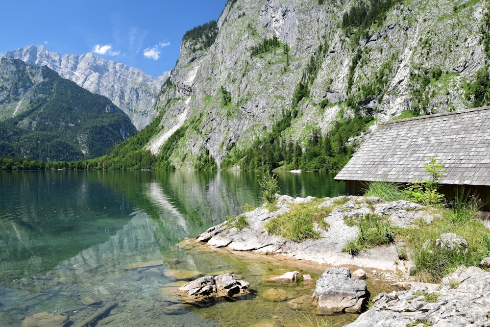 a lake with a house and mountains in the background