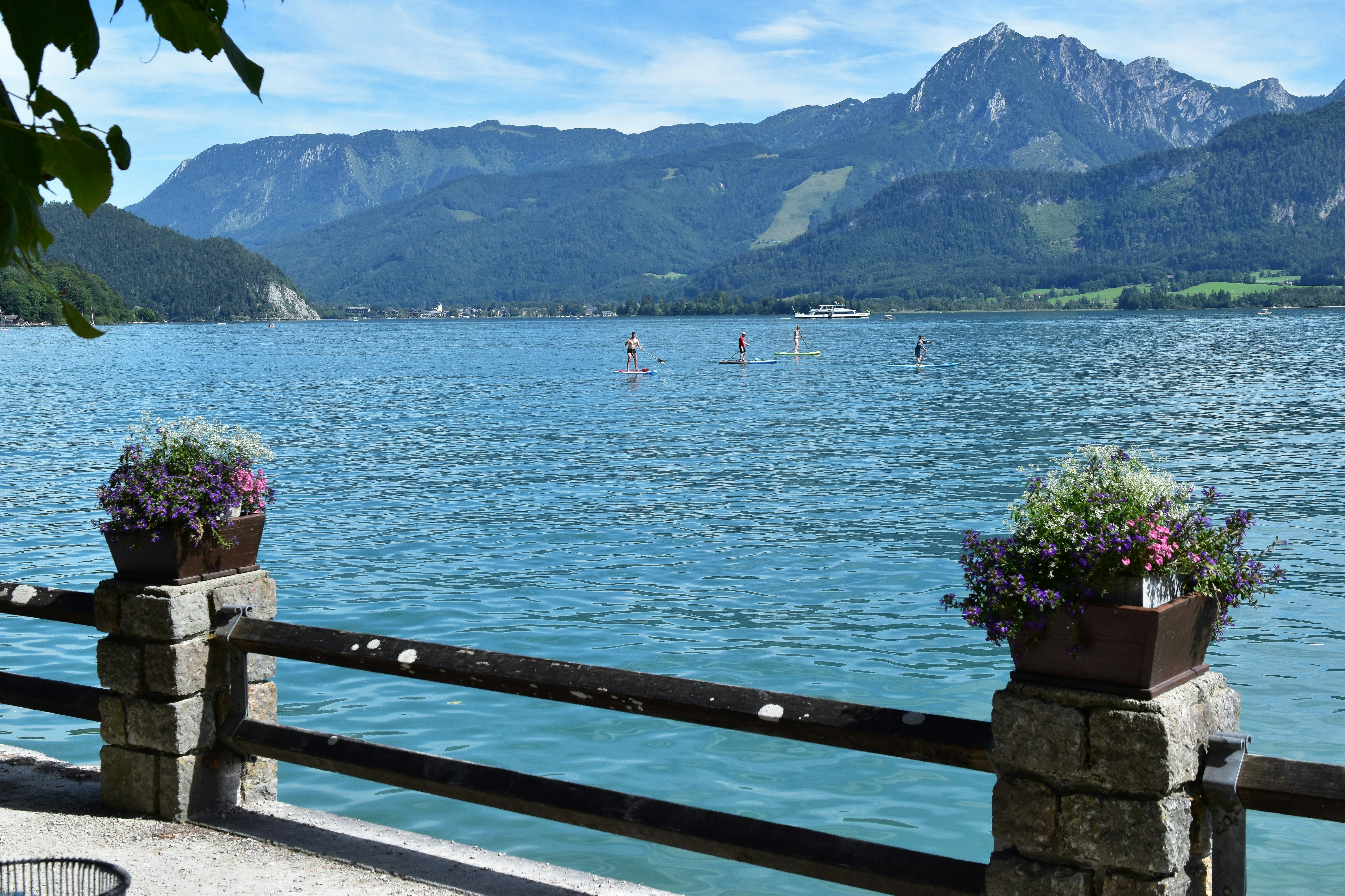 a body of water with boats in it and mountains in the background