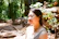 A joyful individual smiling peacefully in a sunlit forest clearing.