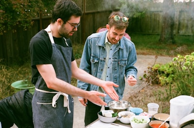 a couple of men cooking outside