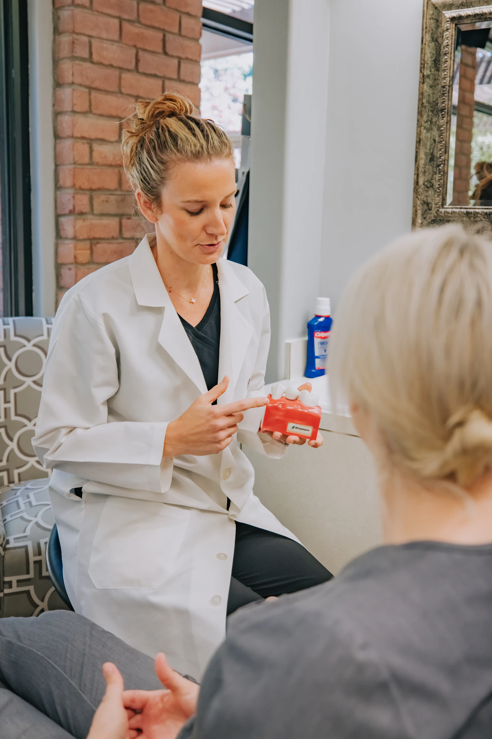 A healthcare provider in a white coat speaking with a patient in a clinical setting
