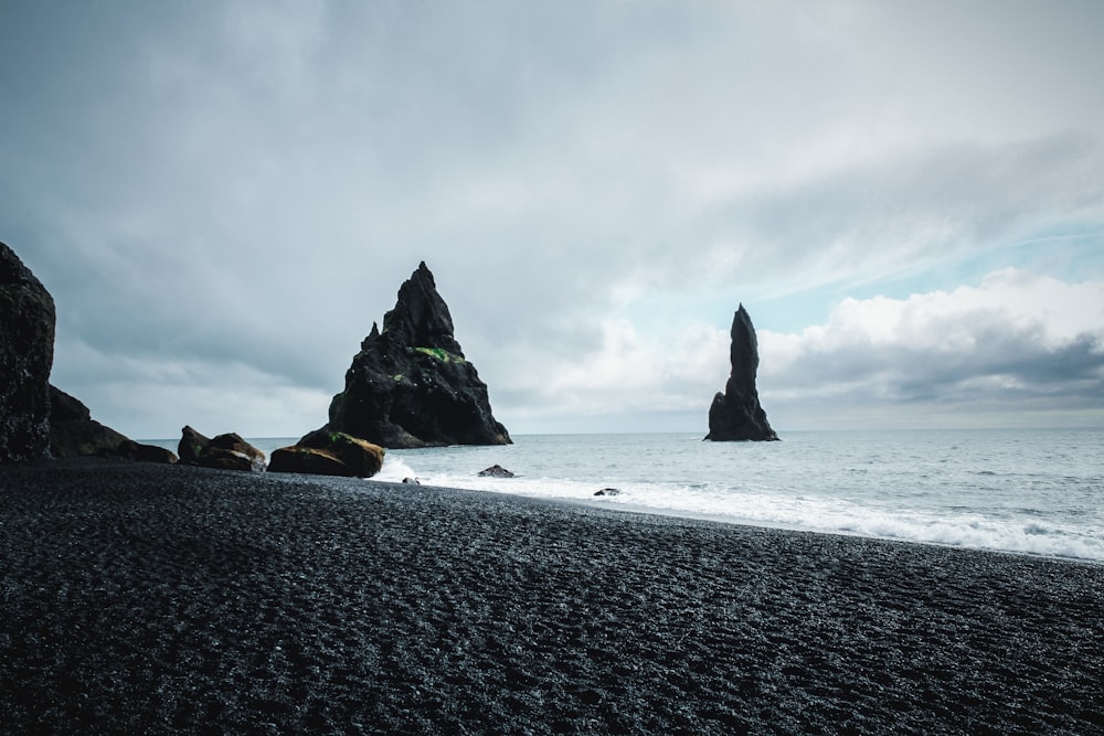 a rocky beach with large rocks in the water