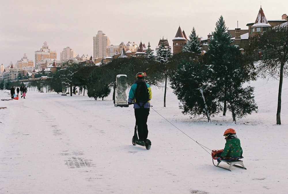a person pulling a sled with a child on it