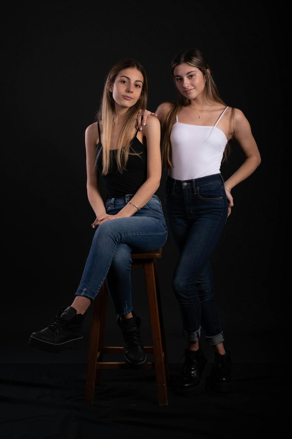 two women sitting on stools