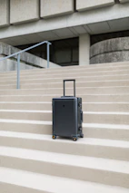 A sleek, modern suitcase standing upright on a polished floor, symbolizing travel and adventure.
