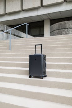 A durable suitcase standing upright with its expandable section partially open.
