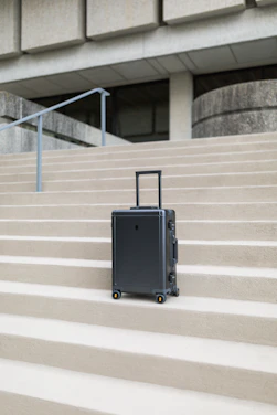 A stylish, modern trolley bag standing confidently on a smooth airport floor, bathed in soft natural light.