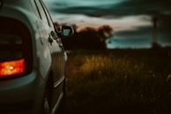 A roadside assistance team helping a car with a flat tire at dusk.