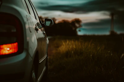 Tow truck pulling a car on a quiet roadside at dusk.