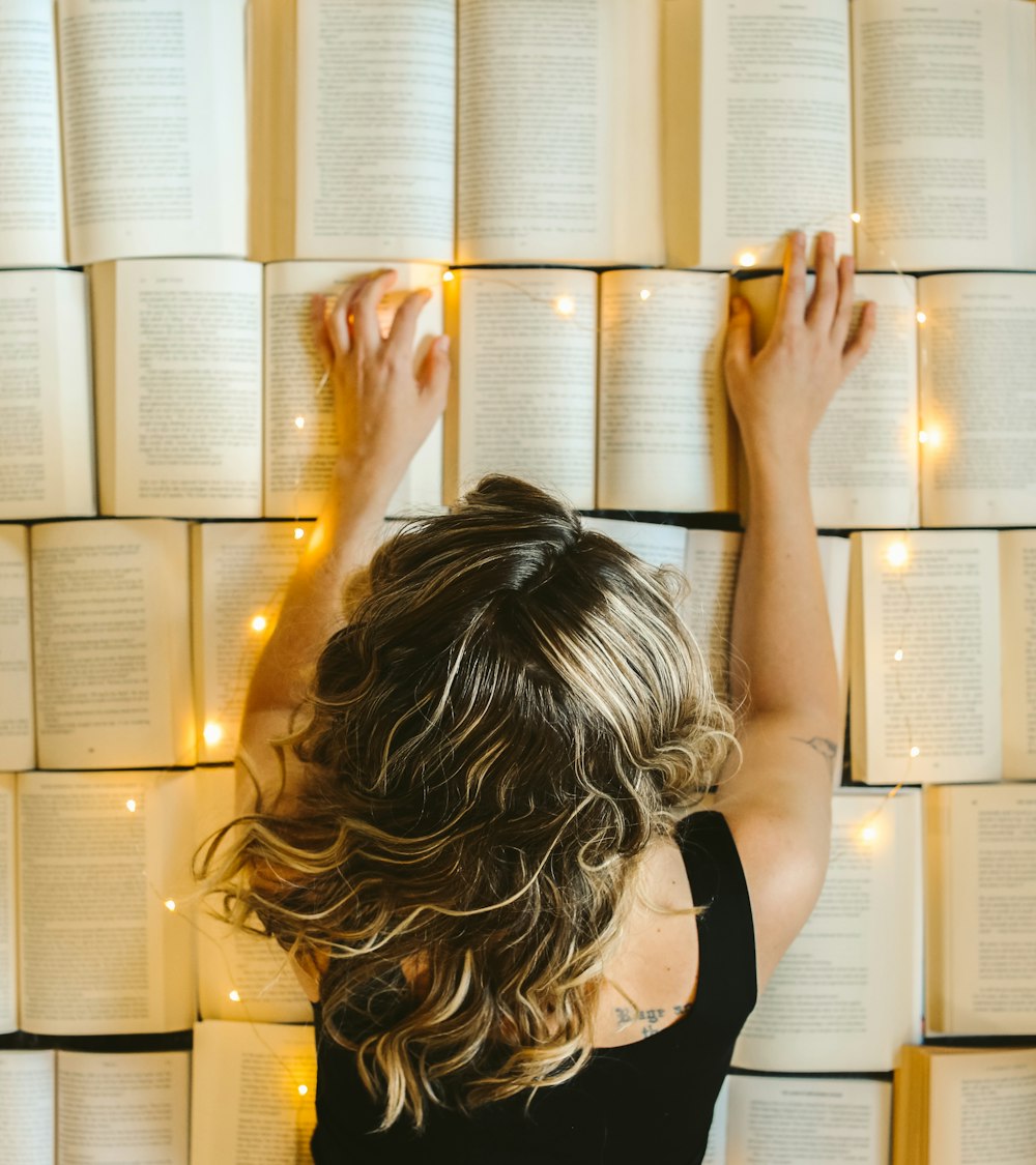 a woman with her hands up in front of a stack of papers