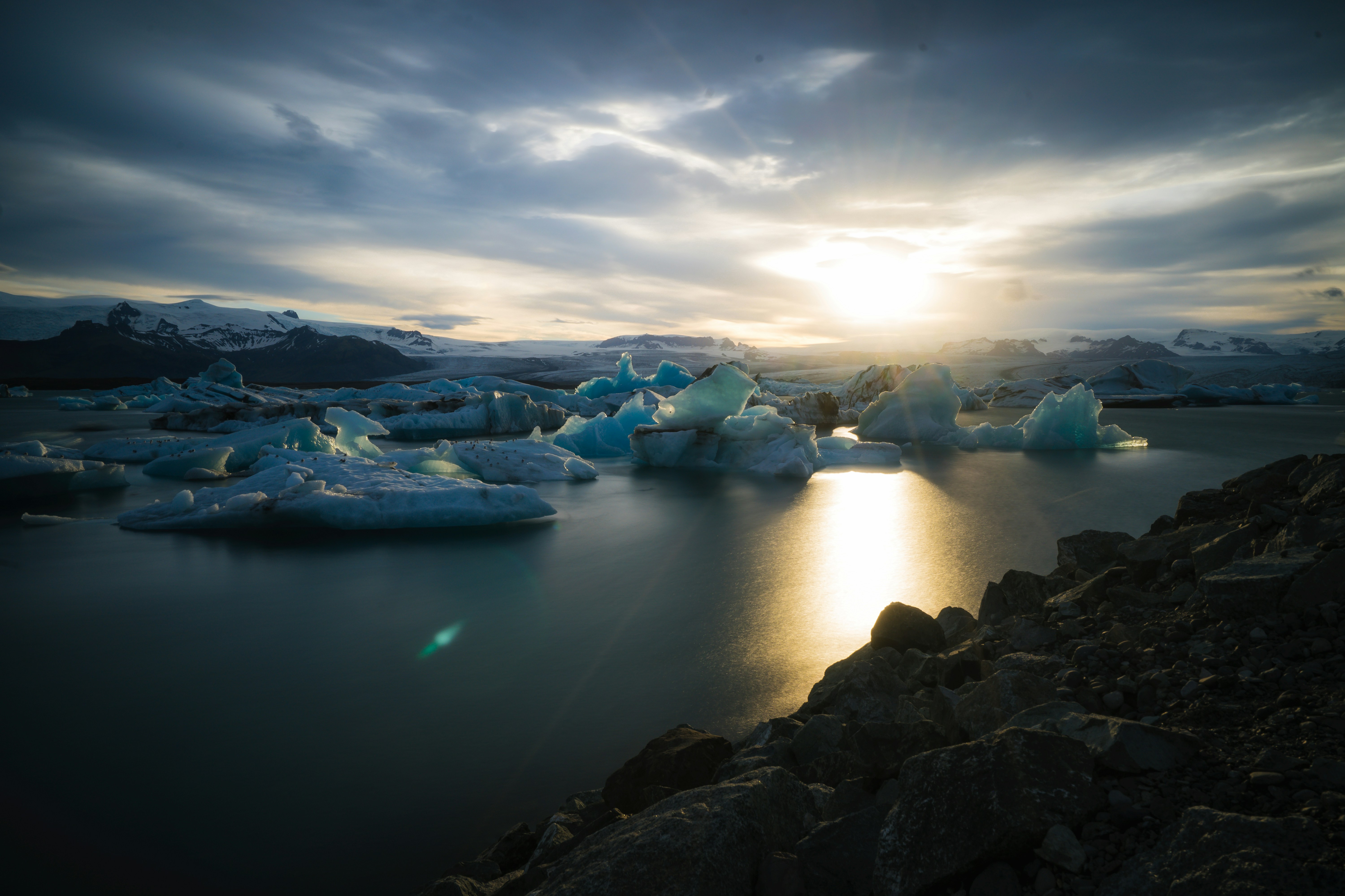 uno specchio d'acqua con ghiaccio e neve sul lato