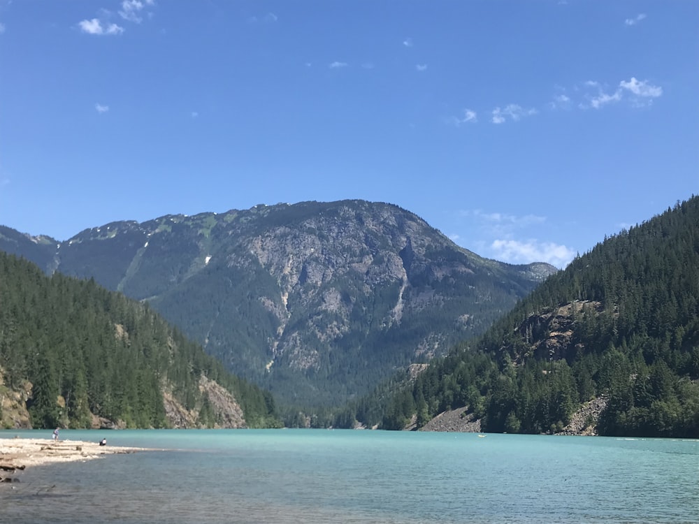 a body of water with mountains in the back