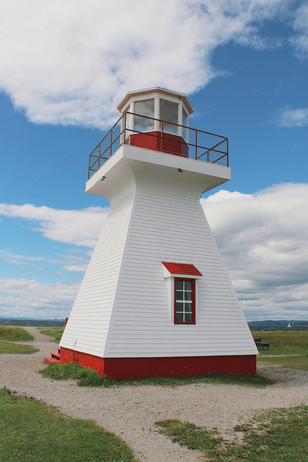 a white lighthouse with a red and white top