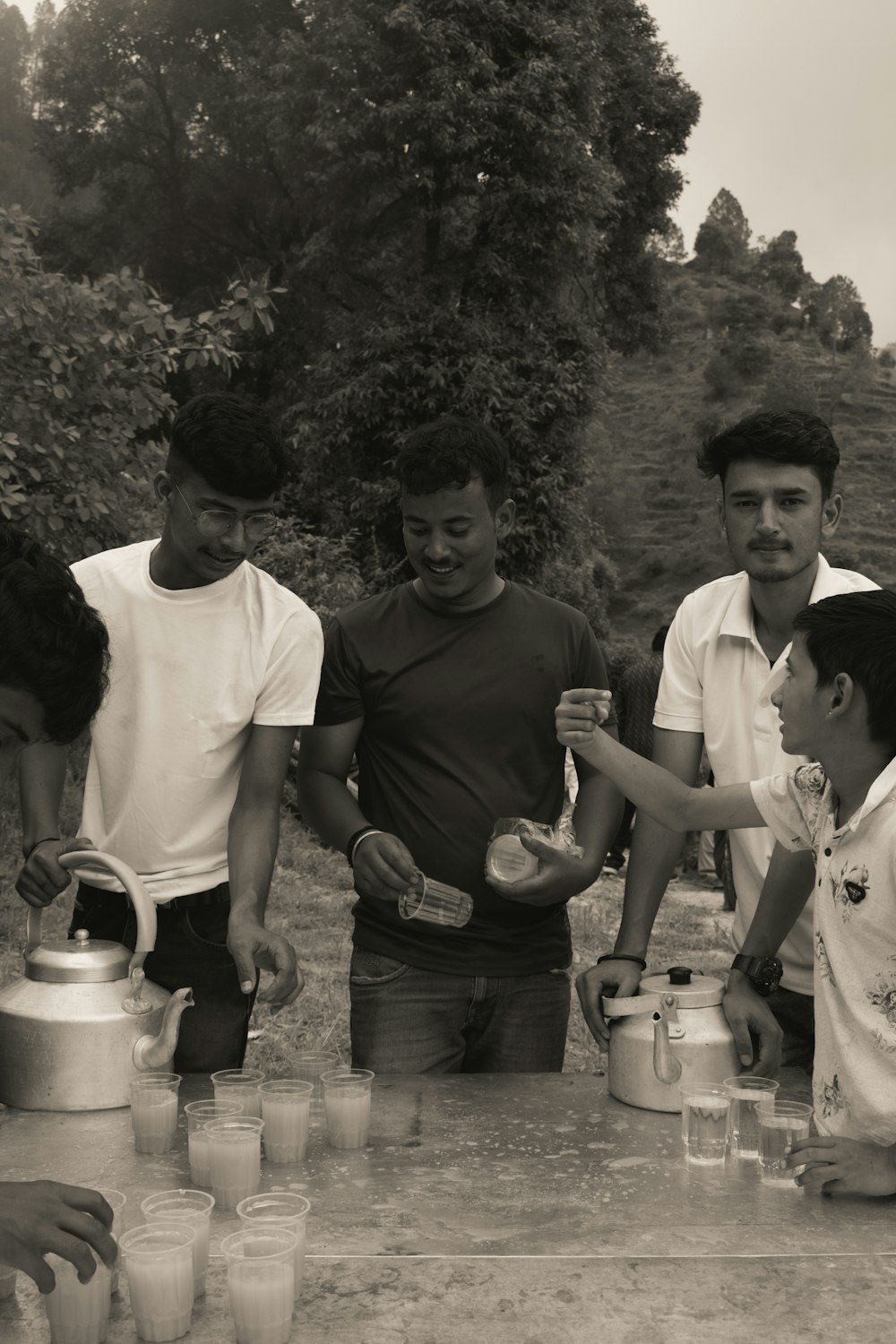 a group of men standing around a table with cups and cups