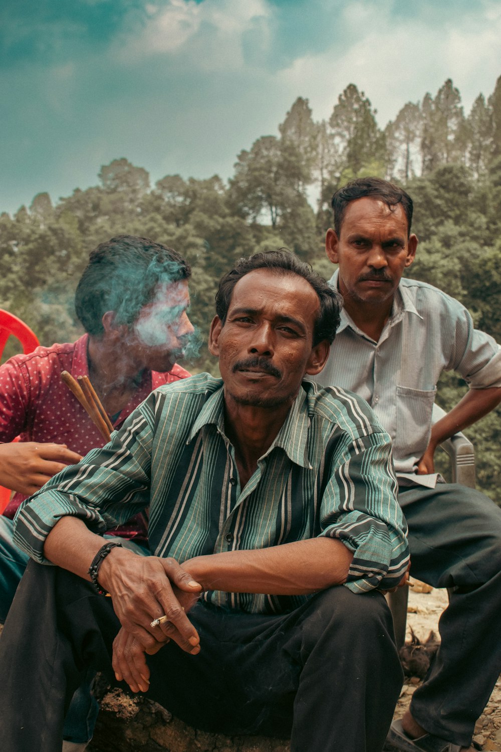 a group of men sitting on a rock posing for the camera