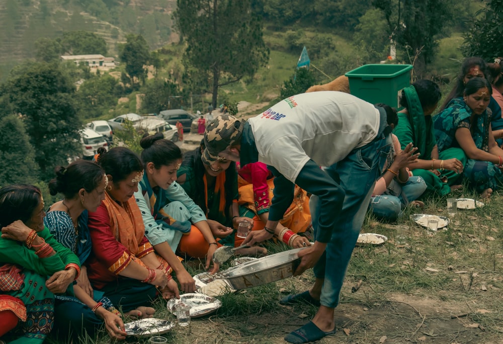 a person pouring a liquid into a container with a group of people