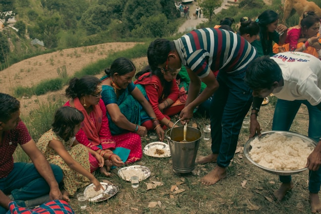 a group of people sitting around a table with food on it