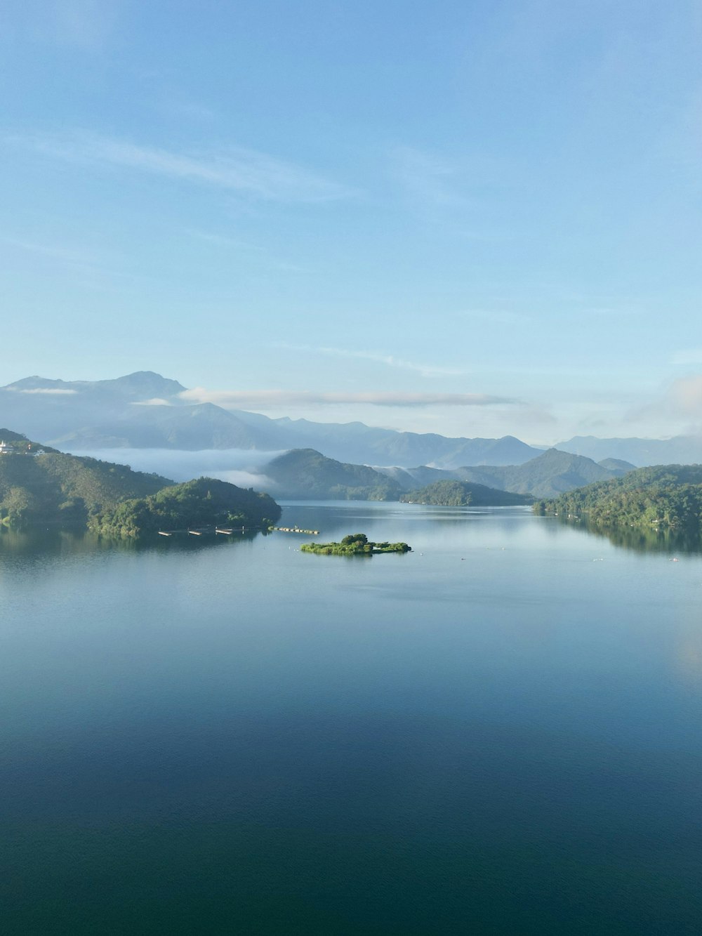 a body of water with trees and mountains in the background