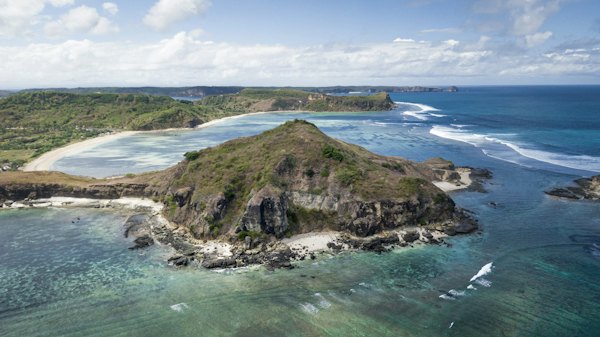 A small island with a body of water and land in the background — Lombok, Indonesia
