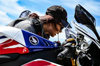 Close-up of a craftsman applying paint protection film on a high-end motorcycle.