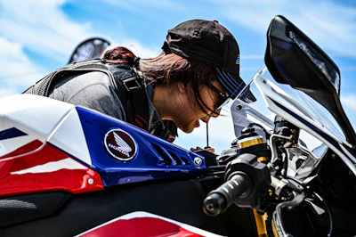 Close-up of a craftsman applying paint protection film on a high-end motorcycle.