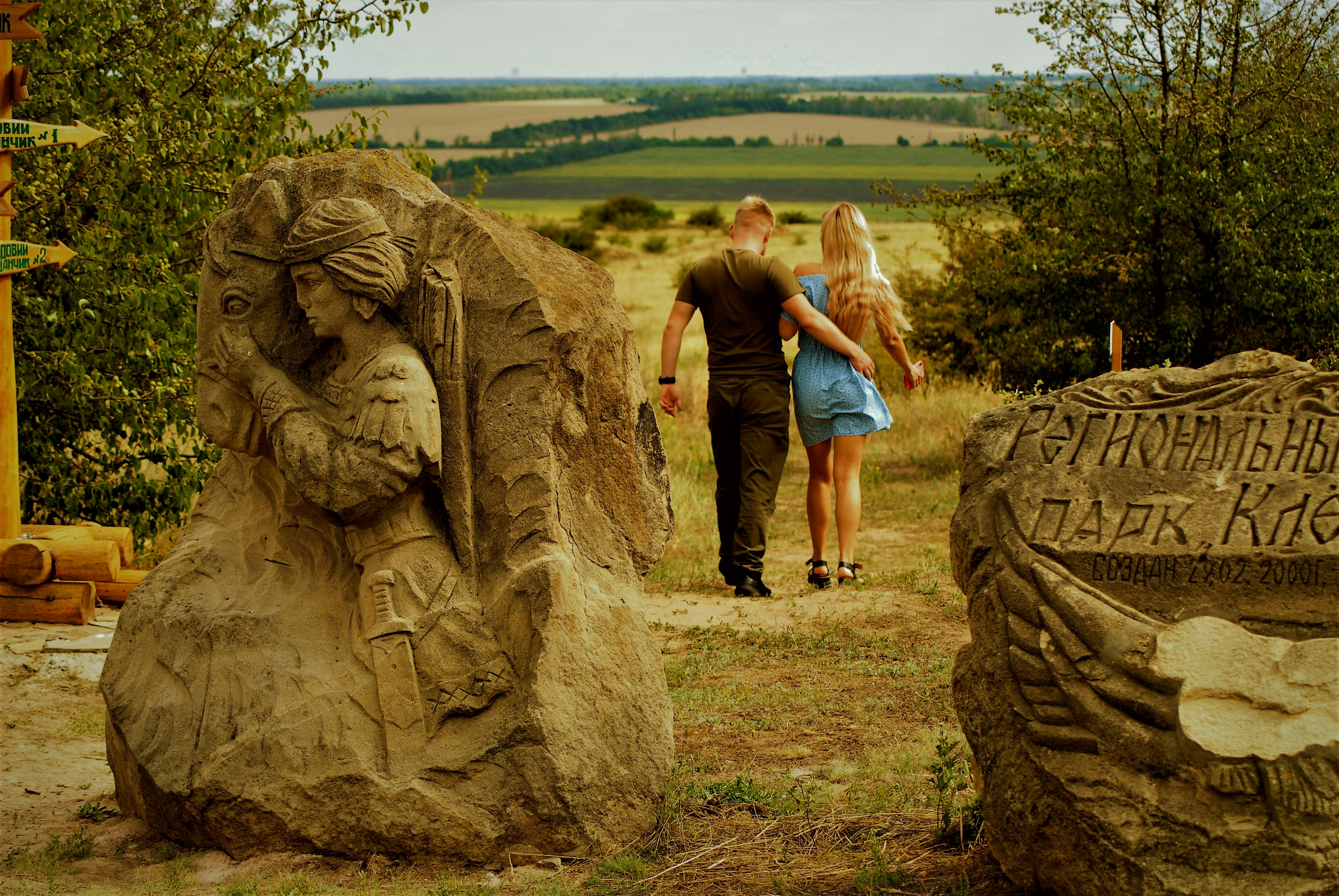 a man and woman standing next to a statue of a lion