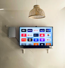 Smart TV mounted on the wall with popular channels and streaming options available.