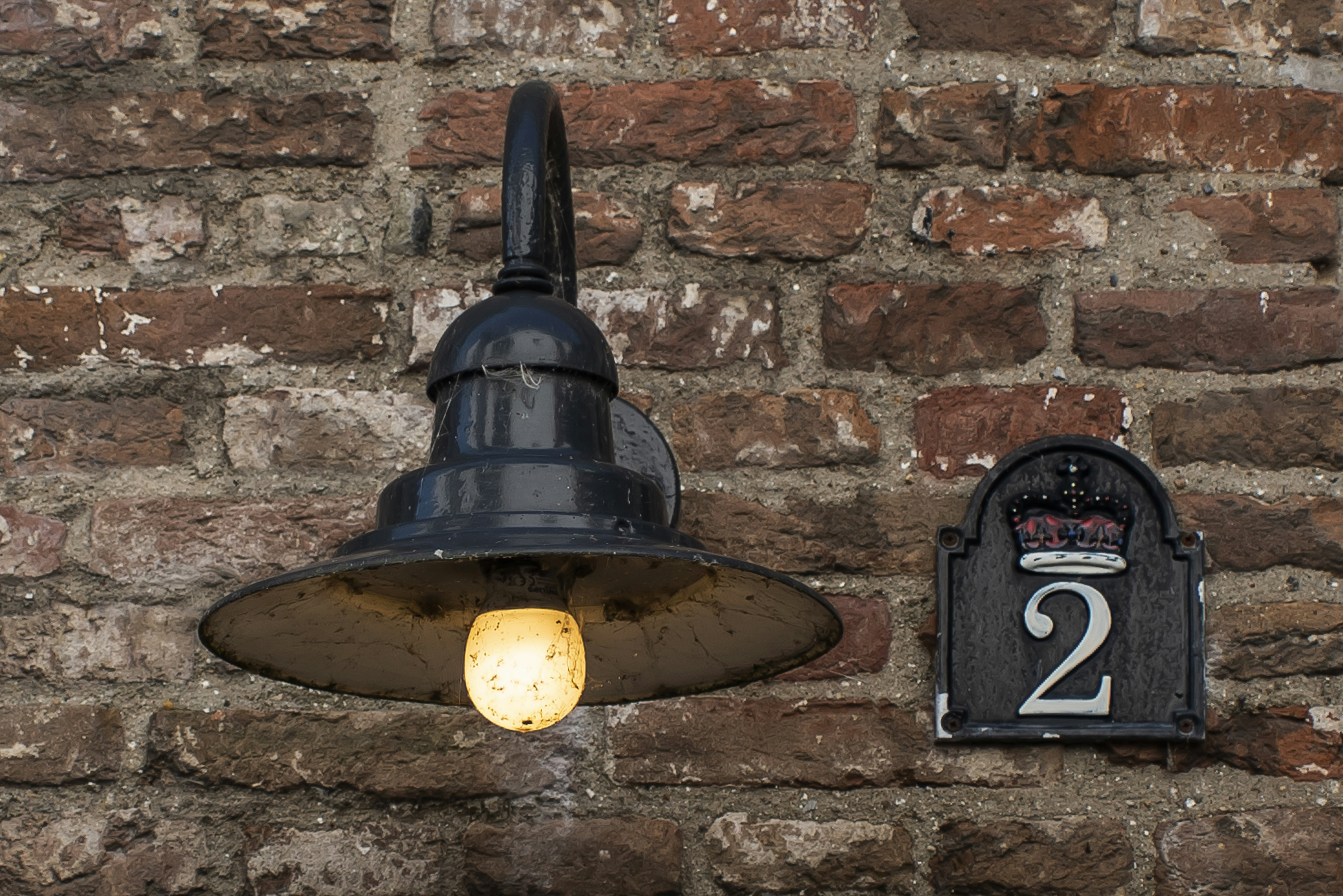a black and silver bell on a brick wall