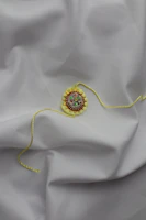 A festive ornament decorated with colorful embroidery threads and patterns.