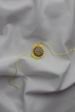 A festive ornament decorated with colorful embroidery threads and patterns.