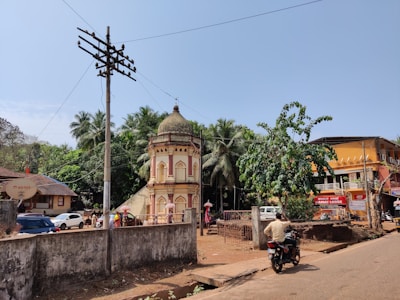 A developed residential plot with road access and electricity poles near local temples.