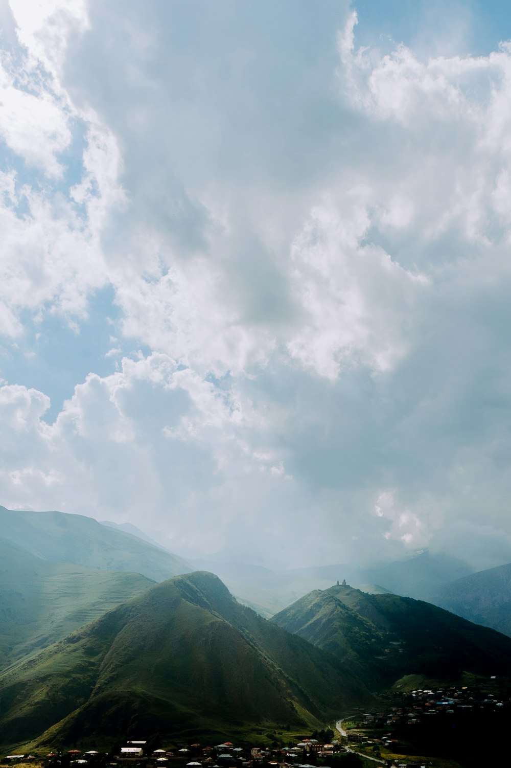 a landscape with mountains and clouds