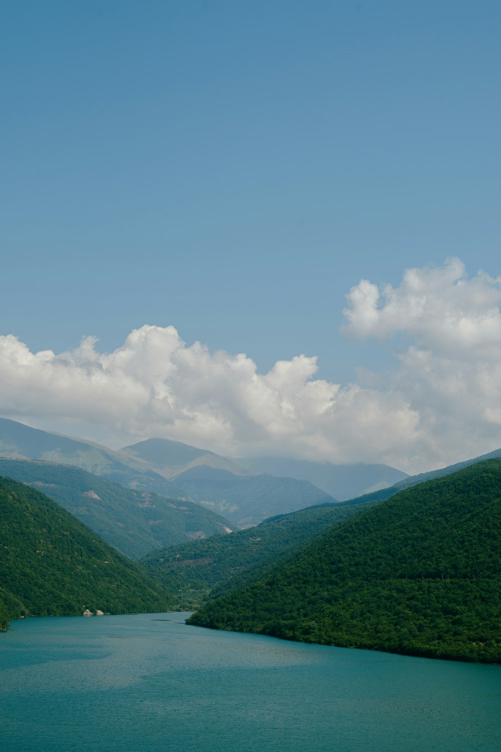 a body of water with hills in the back