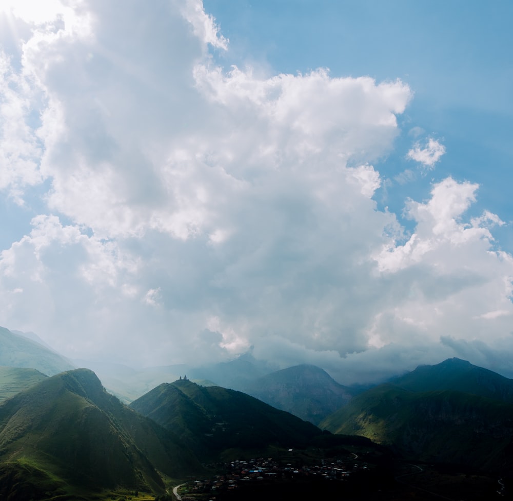 a landscape with mountains and clouds