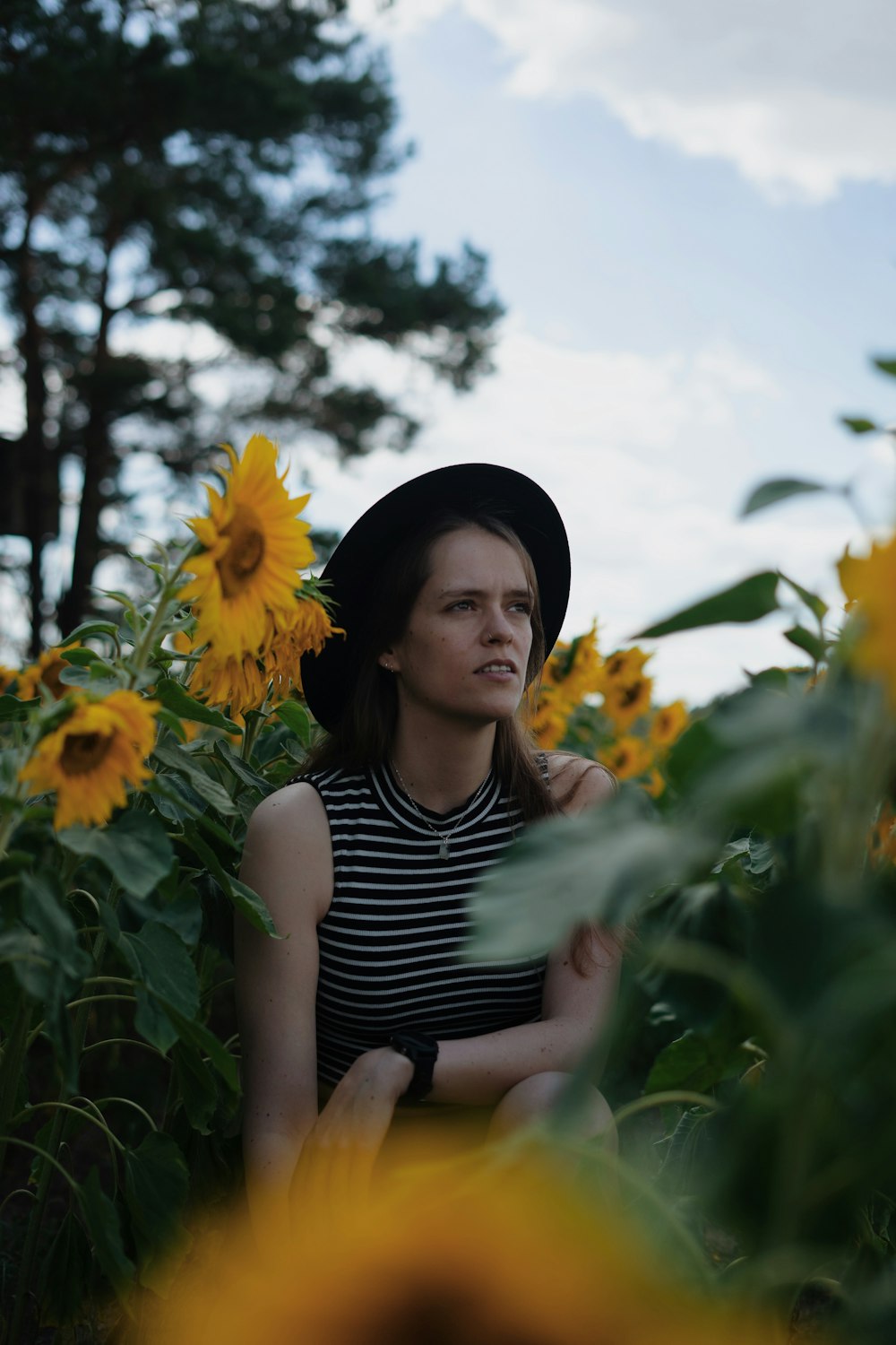 Una donna seduta in un campo di girasoli