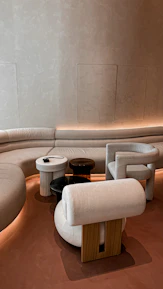 An inviting interior shot featuring plush seating and tasteful decor in deep espresso and warm beige tones.
