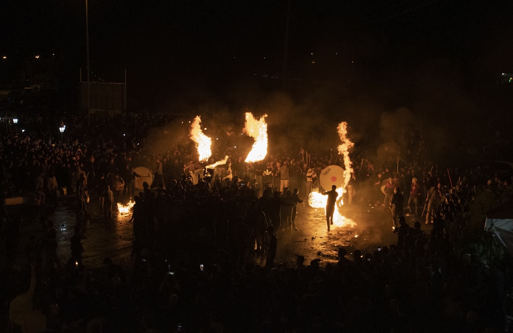 a crowd of people around a fire