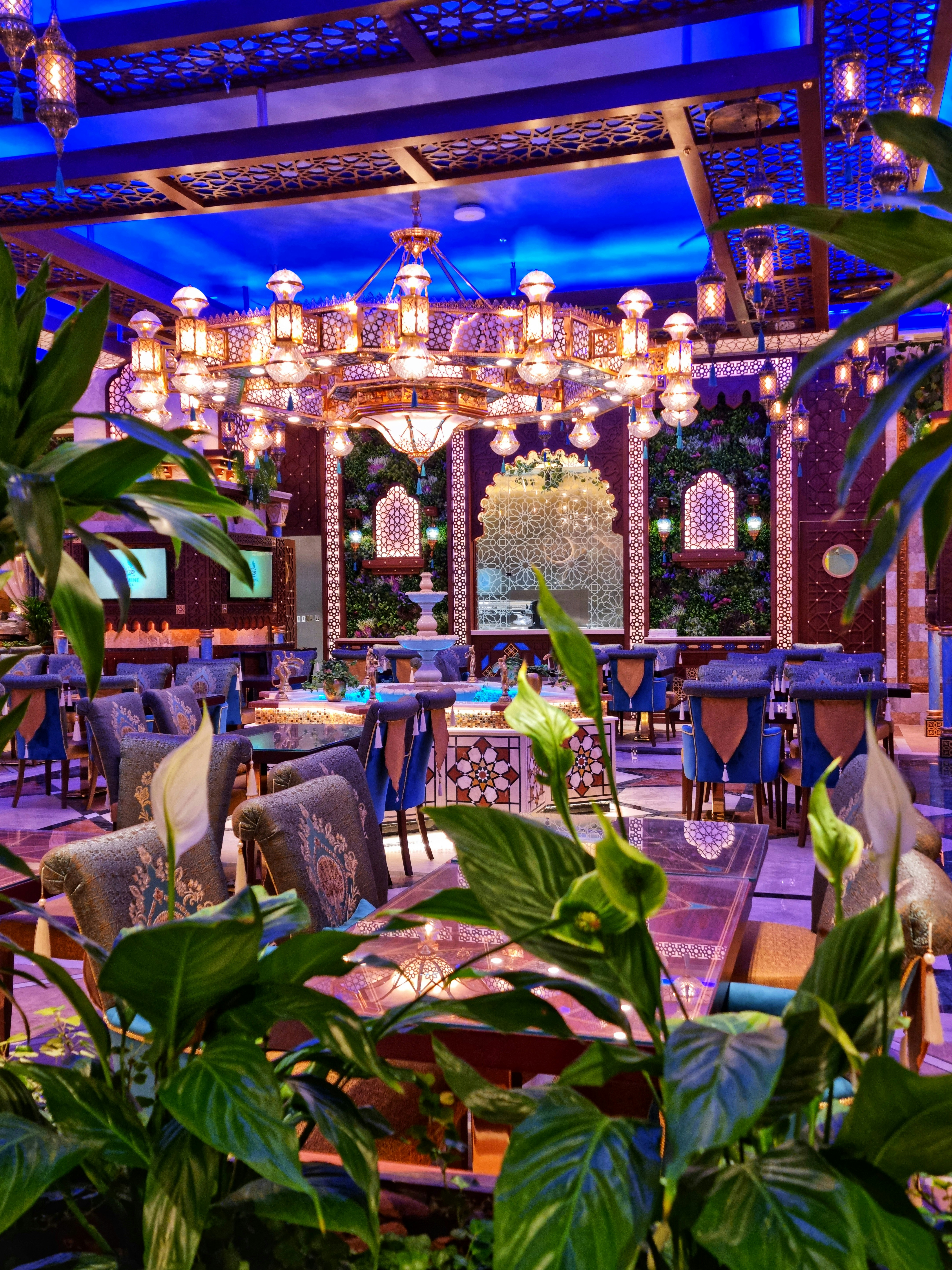 Traditional Arabian restaurant interior with warm amber lighting, ornate lanterns and family dining setting